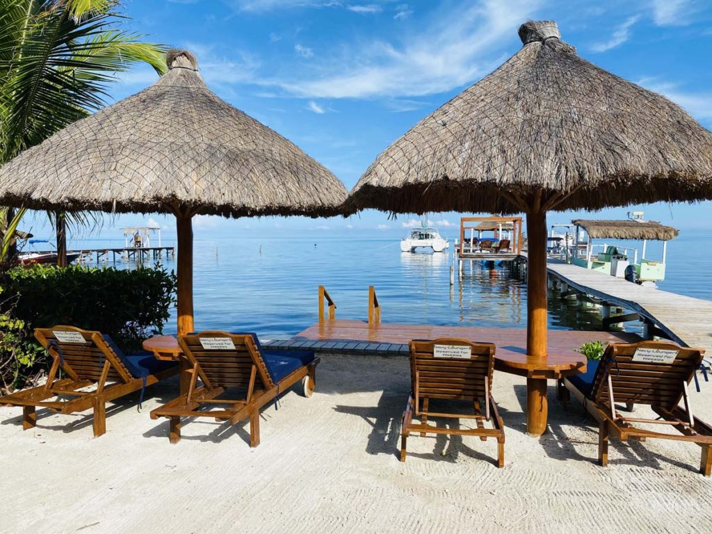Weezies oceanfront hotel caye caulker sun chairs and palapa umbrellas